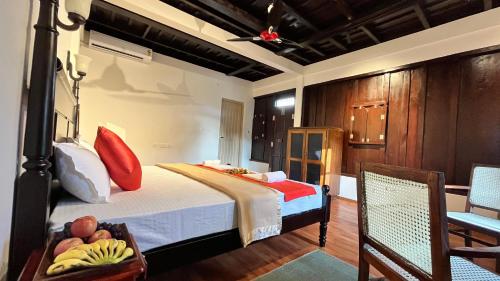 a bedroom with a bed and a table and chairs at Gypsea Marari in Alleppey