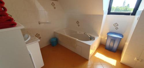 a white bathroom with a tub and a sink at Maison Rose heerlijk ontspannen in luxe in Castelnaud La Chapelle