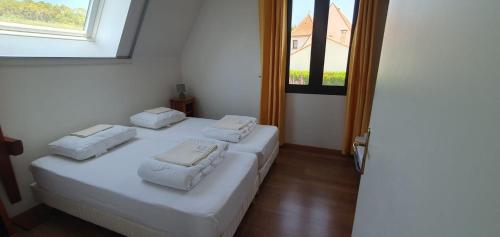 a bedroom with two beds with white sheets and a window at Maison Rose heerlijk ontspannen in luxe in Castelnaud La Chapelle
