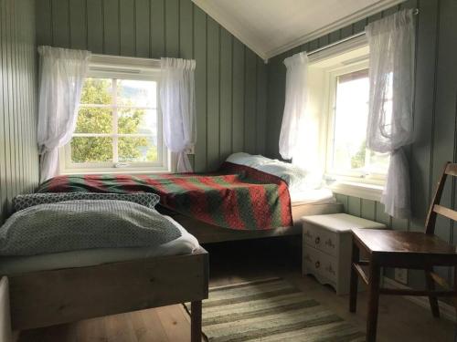 a bedroom with two beds and two windows at The Olav-house from 1840, at farm Ellingbø in Vang I Valdres