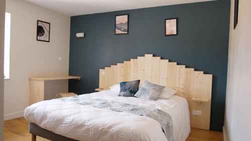 1 dormitorio con 1 cama grande y cabecero de madera en Relais des Monts du Lyonnais en Les Halles