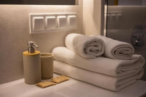 uma pilha de toalhas num lavatório na casa de banho em Metro Kabaty Elegant Apartment em Varsóvia