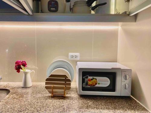 a microwave sitting on a counter in a kitchen at Executive Studio Clara by House of Cleo in Manila