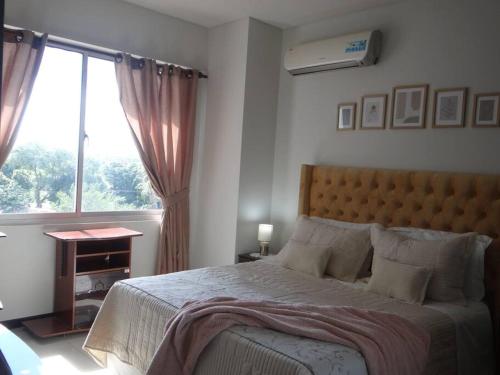 a bedroom with a large bed and a window at Hermoso departamento 91 MT2, PISCINA GRANDE y lindas áreas comunes in Santa Cruz de la Sierra