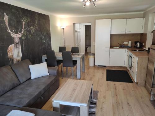 Una sala de estar con un sofá y una mesa y una cocina. en Gästehaus Harzklause 1, en Sieber