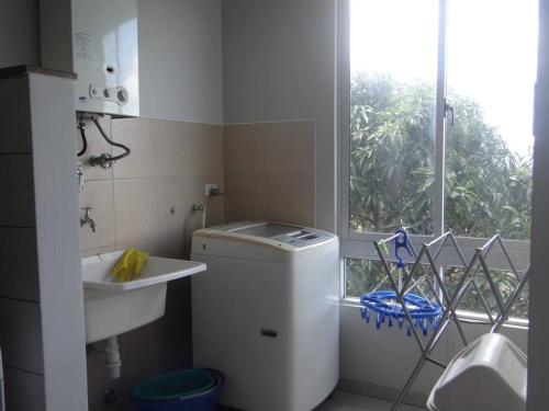 uma pequena casa de banho branca com um lavatório e uma janela em Lindo DPTO en Condominio Cama KING em Santa Cruz de la Sierra