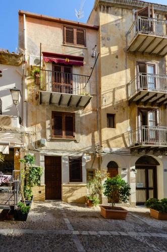 an old building with windows and balconies on a street at A due passi dal Duomo in Cefalù
