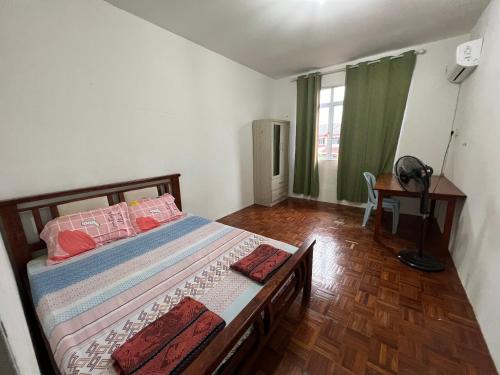 een slaapkamer met een bed, een bureau en een raam bij Leng Leng Homestay in Sibu