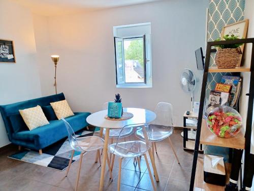 - un salon avec une table et un canapé bleu dans l'établissement Le Peyragudes - Rue de la Grotte - 36m, à Lourdes