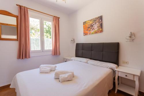 1 dormitorio con 2 camas y ventana en Villas Nord & Sud 83AB, Son Bou By MENORCARENTALS, en Son Bou
