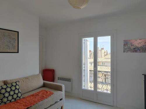un soggiorno con divano e finestra di Superbe T3 terrasse avec vue Centre historique a Montpellier