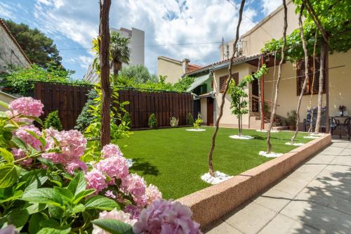 un jardin avec des fleurs roses et une clôture dans l'établissement Antique Garden Villa, à Split
