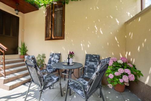 patio ze stołem, krzesłami i kwiatami w obiekcie Antique Garden Villa w Splicie