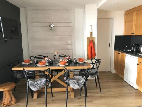 une salle à manger avec une table et des chaises en bois dans l'établissement Oursblanc834, à Huez