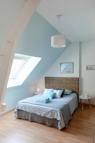 une chambre avec un lit avec un plafond bleu dans l'établissement La Tanière, à Brette-les-Pins