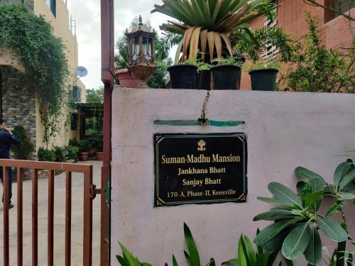 a sign on a wall with potted plants on it at Suman Madhu Mansion in Nānodra
