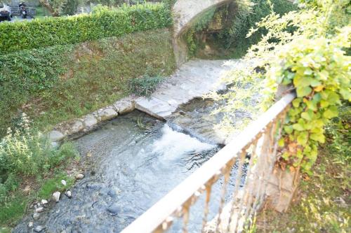 a small stream of water next to a bridge at Casa Cometa Designer Attic Menaggio in Menaggio