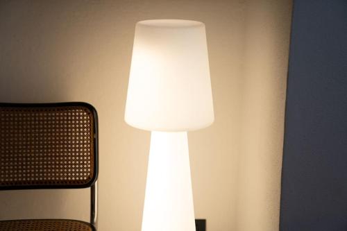 a white lamp on a wall next to a chair at Casa Cometa Designer Attic Menaggio in Menaggio
