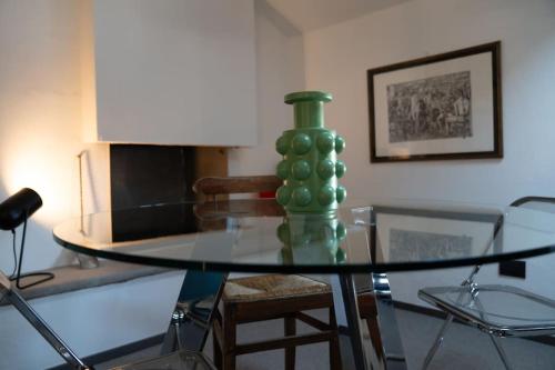 a glass table with a green vase on top of it at Casa Cometa Designer Attic Menaggio in Menaggio