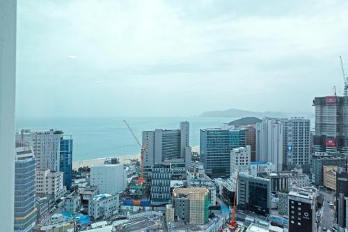 a city with tall buildings and the ocean at Elmomento Haeundae in Busan