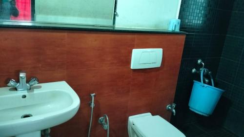 a bathroom with a sink and a toilet and a mirror at Tulips Misty hights 2BHK villa in Yelagiri