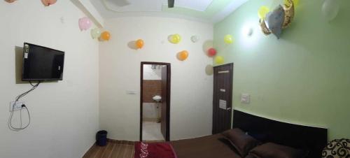 een kamer met een tv en ballonnen aan de muur bij OYO Hotel Mongoose Palace in Narela