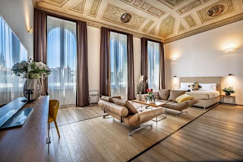 ein großes Wohnzimmer mit einem Sofa und einem Bett in der Unterkunft Rivalta Hotel - Alfieri Collezione in Florenz