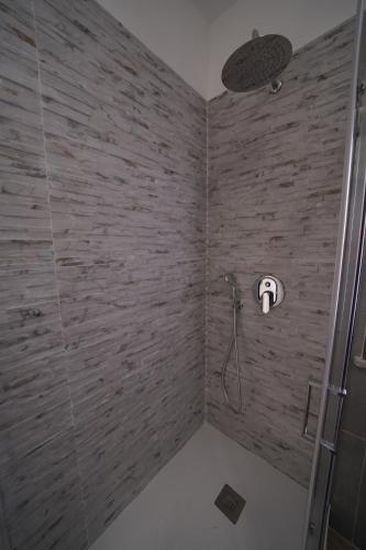 a bathroom with a shower with a brick wall at Regina Stella in Lascari