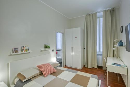 ein weißes Schlafzimmer mit einem Bett und einem Schreibtisch in der Unterkunft Vico 4 Rooms in Turin