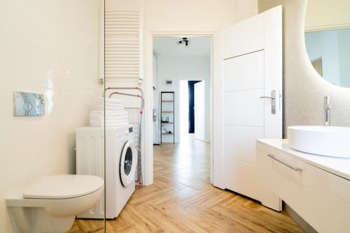 ein weißes Badezimmer mit einer Waschmaschine und einem Waschbecken in der Unterkunft Warszawska 206 I Piętro in Radom