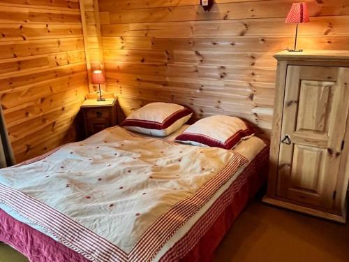 une chambre avec un lit dans une cabane en rondins dans l'établissement Appartement rénové pour 8 pers, skis aux pieds - FR-1-322-191, aux Orres