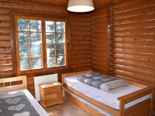 une chambre avec un lit dans une cabane en rondins dans l'établissement Chalet en Pierre avec Cheminée, 3 Chambres & Balcon, WIFI, Bolquère - 7 pers - FR-1-592-26, à Bolquère-Pyrénées 2000