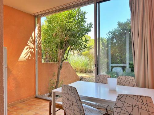 une table et des chaises dans une pièce avec une fenêtre dans l'établissement Appartement T2 avec Jardin, Parking et Climatiseur - Proche Plage Bormes-les-Mimosas - FR-1-251-436, à Bormes-les-Mimosas