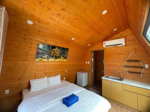 - une chambre avec un lit dans une pièce en bois dans l'établissement Tân Thành Resort, à Ke Ga