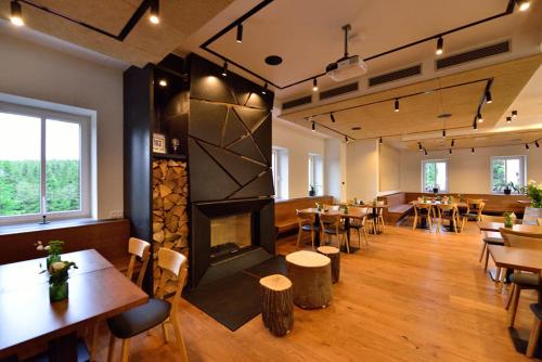 um restaurante com mesas e cadeiras e uma lareira em Horská chata Smědava em Weissbach