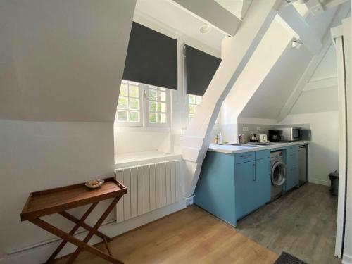 une petite cuisine mansardée avec lave-linge et sèche-linge dans l'établissement Appartement BELLE VUE MER dans la Tour du Château de Trestraou à PERROS-GUIREC - Réf 865, à Perros-Guirec