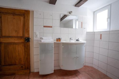 a white bathroom with a sink and a mirror at Wohnen in malerischer Altstadt in Siegen