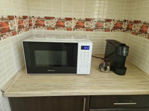 a microwave sitting on a counter in a kitchen at Апартаменты в тихом месте in Chişinău