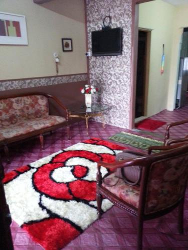 a living room with a rug on the floor at Homestay Sri Perhentian Pontian in Pontian Kecil