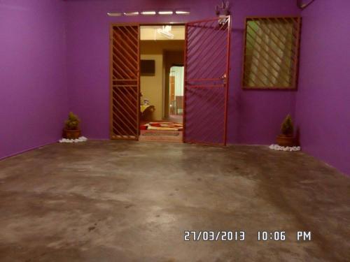 an empty room with purple walls and an open door at Homestay Sri Perhentian Pontian in Pontian Kecil