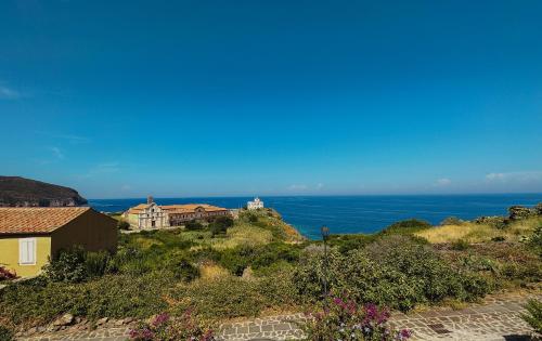 a house on a hill with the ocean in the background at Casa Rais Dragut in Capraia