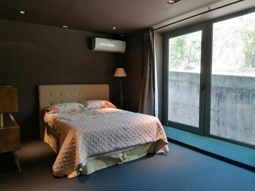 - une chambre avec un lit et une grande fenêtre dans l'établissement L'Orangerie - Villa with private indoor swimming pool and hammam, à Portalegre