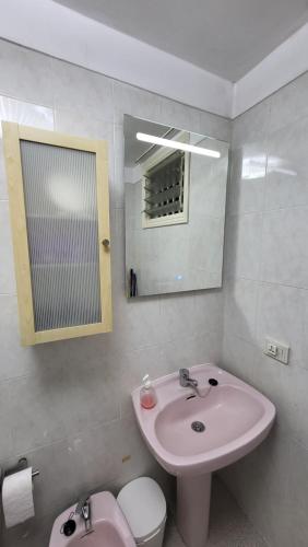 a bathroom with a sink and a toilet and a mirror at Casa Mina in Puerto de Santiago
