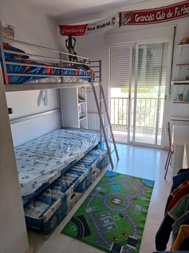 a room with a bunk bed and a rug at Casa María in Gabia la Chica