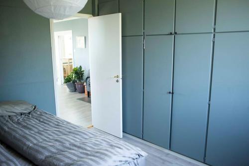 a bedroom with a bed and blue cabinets at 5 minutes to downtown Arendal in Arendal