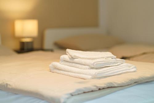 a stack of white towels sitting on a bed at Großzügiges Apartment mit Balkon für Monteure und Feriengäste in Pachten