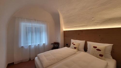 - une chambre avec un lit blanc et une fenêtre dans l'établissement Fruemess - Historic Refugium, à Parcines