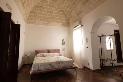 a bedroom with a bed and a window in it at Dimora Antelmi - Tra Cielo & Mare in Ostuni