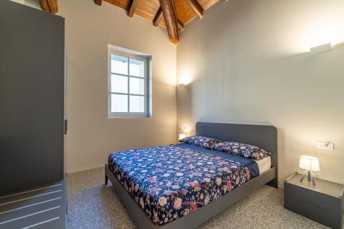 una camera da letto con un letto con un piumone blu e una finestra di Elegante Loft a 200 a metri dal Duomo a Como