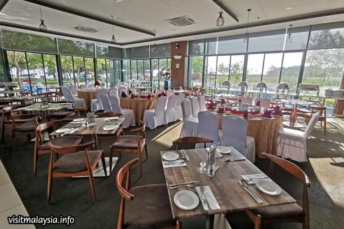 a dining room with tables and chairs and windows at PD D’Wharf Seaview & Sunset Suite (Up to 6 Pax) in Port Dickson